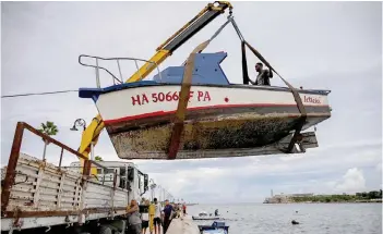  ?? — AFP photo ?? People pull small boats out of Havana Bay in Havana, as Cuba is expected to bear the brunt of Hurricane Ian.