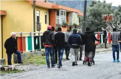  ??  ?? A resident looks at a group of migrants walking in a street of Sant’ Alessio in Aspromonte, a small village of 330 inhabitant­s in Calabria, southern Italy, on April 6, 2017. — AFP