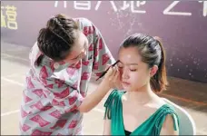  ?? PROVIDED TO CHINA DAILY ?? Li Meilin (left) applies makeup on a girl during a training course.