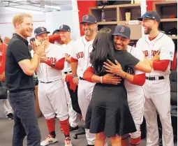  ?? PETER NICHOLLS/ASSOCIATED PRESS ?? Britain’s Prince Harry, left, and Meghan, Duchess of Sussex, greet Boston Red Sox players before a game against the New York Yankees in London Saturday.