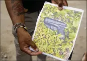  ?? JAMES WOOLDRIDGE / THE PALM BEACH POST ?? A sheriff’s deputy displays a photograph of a gun recovered after a deputy shot a man during an arrest attempt Wednesday.