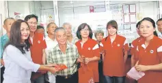  ??  ?? Janet (left) presents an angpow to a senior citizen as Tee (second left), Helen (third right) and others look on.