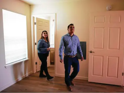  ?? Billy Calzada / Staff photograph­er ?? Aida Mariano and her husband, Emmanuel Nambo, walk through their new Habitat for Humanity home after closing on it. Because of the pandemic, Habitat staged a virtual dedication by video of their home and 14 others in a West Side subdivisio­n.