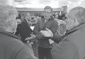  ?? MIKE CARDEW/AKRON BEACON JOURNAL ?? U.S. Rep. Tim Ryan, center, talks with George Jaskiw and Peter Fedynsky during a campaign stop at Pokrova Ukrainian Greco-catholic Church in Parma on April 2.