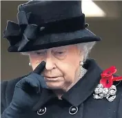  ??  ?? A tear is visible below the Queen’s right eye, above. She wipes it away with her hand, left, as she watches yesterday’s ceremony from a Foreign Office balcony