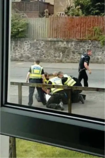  ??  ?? Subdued: Police are seen holding a man down after a fellow officer rugby-tackled him to the ground