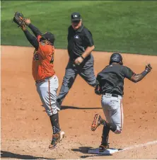  ?? Gabrielle Lurie / The Chronicle ?? Pablo Sandoval reaches for a high throw as Marco Luciano crosses the bag with a single in Sunday’s intrasquad game.