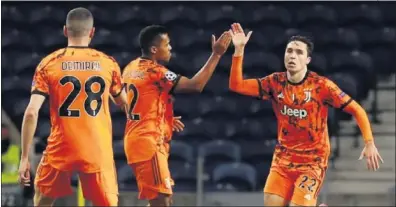  ??  ?? Chiesa celebra con Alex Sandro y Demiral el gol que marcó anoche ante el Oporto.