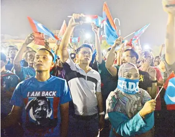  ??  ?? This photograph taken on May 16, 2018 shows Malaysian Pakatan Harapan (Pact of Hope) coalition supporters waving party flags during a rally following the release of jailed Pakatan Harapan coalition leader Anwar Ibrahim following the results of the...