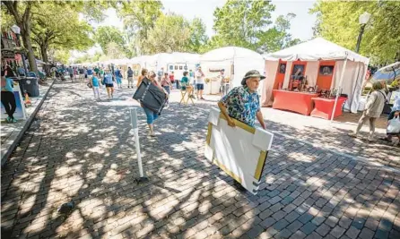  ?? PATRICK CONNOLLY/ORLANDO SENTINEL ?? Patrons and visitors wander more than 200 artist booths and purchase artwork at the Winter Park Sidewalk Art Festival in 2022.