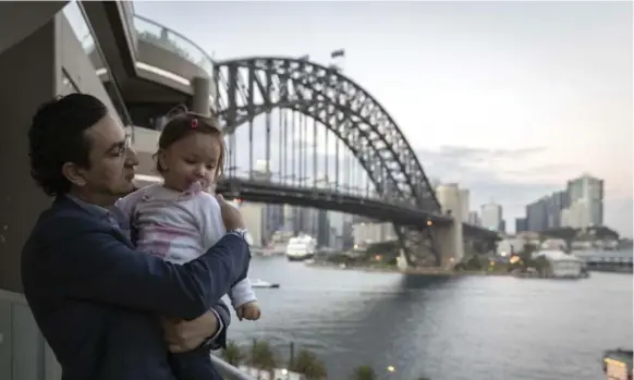  ?? BROOK MITCHELL PHOTOS/THE NEW YORK TIMES ?? Dr. Munjed al-Muderis, an Iraqi-Australian orthopedic surgeon with his daughter Amelia, in Sydney, where he lives on the harbourfro­nt and works at a private hospital.