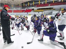  ??  ?? South Korea’s ice hockey team coach Jim Paek, left, speaks to his players during a February practice at a rink in Goyang, northwest of Seoul.