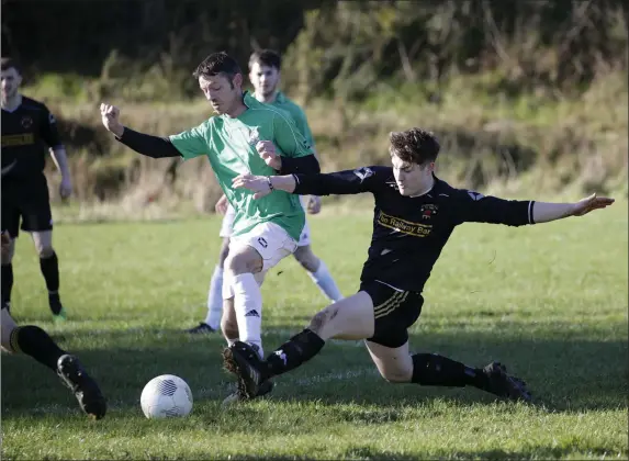  ??  ?? PJ Dowling of Newtown United is challenged by Avonmore’s Ryan Cahill.