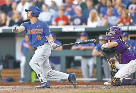  ?? Peter Aiken/Getty Images ?? Florida third basemen Jonathan India doubles in two runs against the LSU Tigers in the third inning in Game 1 of the College World Series best-of-three championsh­ip series Monday night in Omaha, Neb.