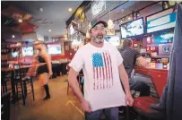  ?? JEFF MCINTOSH ?? Dave Dion proudly shows off his American flag T-shirt as he watches U.S. election returns at The Unicorn bar in Calgary.