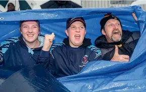  ?? LISA BURD/STUFF ?? Emma Gyde, 17, Liam Gyde, 15, and Kevin Gyde came prepared as a deluge of rain hit Yarrow Stadium during the Bulls’ first game back.