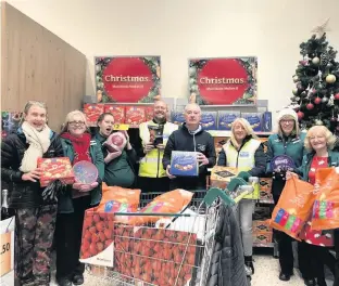  ??  ?? ●● Runners from Whitworth trail races teamed up with Bacup Morrison’s to help the homeless at Christmas by donating £200 worth of food