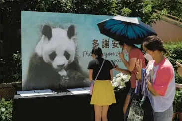  ?? KIN CHEUNG/AP ?? Visitors write notes to mourn the death of the oldest male giant panda in captivity Thursday at a theme park in Hong Kong. An An, who had been in deteriorat­ing health, was 35 years old or 105 in human years, the park said. An An and a female panda, Jia Jia, were gifted to Hong Kong by China in 1999. Jia Jia was the oldest panda in captivity when she died in 2016 at 38.