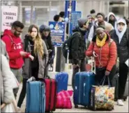  ?? MATT ROURKE — THE ASSOCIATED PRESS ?? Travelers wait in line to board a bus ahead of the Thanksgivi­ng holiday in Philadelph­ia, Tuesday.