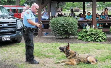  ?? JOHN STRICKLER — DIGITAL FIRST MEDIA ?? Pottstown Police Department K-9 officer Jeffrey Portock and his K-9 partner Taz put on an obedience demonstrat­ion for children attending the Pottstown Parks and Recreation camp Friday at Memorial Park.