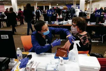  ?? Photos by Kin Man Hui / Staff photograph­er ?? University Health’s Samantha Shane gives a coronaviru­s vaccinatio­n to Petra Braswell on Friday at the Wonderland of the Americas mall. The operation there handles about 3,500 doses per day.