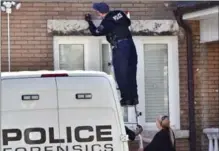  ?? HAMILTON SPECTATOR FILE PHOTO ?? A police officer collects bullets from the brick on the front of Pat Musitano’s Hamilton home.