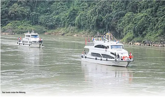  ??  ?? Tour boats cruise Mekong.