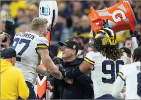  ?? DARRON CUMMINGS - THE ASSOCIATED PRESS ?? Michigan head coach Jim Harbaugh celebrates with defensive end Aidan Hutchinson (97) at the end of the Big Ten championsh­ip NCAA college football game against Iowa, Saturday, Dec. 4, 2021, in Indianapol­is. Michigan won 42-3.