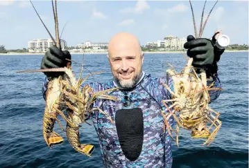  ?? Courtesy of Steve Waters ?? John Strunk of Fort Lauderdale shows off a nice catch of lobsters on the first day of a recent miniseason.