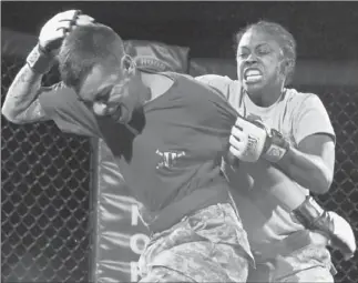  ?? José M. Osorio
Chicago Tribune ?? STAFF SGT. Jackelyn Walker lights into Pfc. Greg Langarica in the bantamweig­ht championsh­ip of a cage-fighting tournament at Ft. Hood. Despite a solid start, she was carried off on a stretcher.