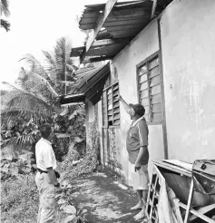  ??  ?? Osman (right) showing Wan the roof that needs to be repaired.