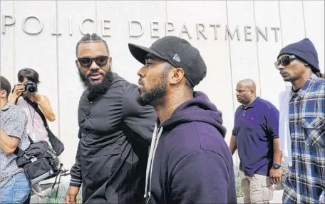  ?? Richard Vogel Associated Press ?? RAPPERS the Game, left, and Snoop Dogg, right, appear at Los Angeles police headquarte­rs to meet with Police Chief Charlie Beck.