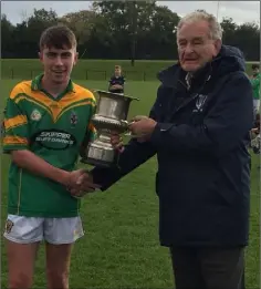  ??  ?? Enniscorth­y captain Jack Mythen collecting the South Leinster Junior ‘B’ hurling cup from Pat Henderson.