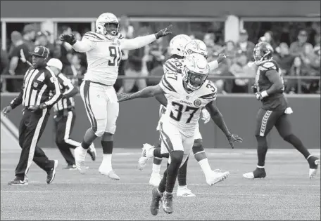  ?? Luis Sinco Los Angeles Times ?? THE CHARGERS’ Jahleel Addae, foreground, and his teammates celebrate after breaking up a pass in the end zone with no time left in the game and clinching the victory. “I don’t know if it affected the path of the ball, but I got a finger on it, I felt it,” Addae said.