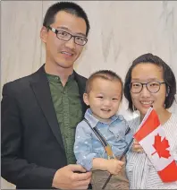  ?? MAUREEN COULTER/THE GUARDIAN ?? Ze Chao Tian, left, and Zhiyu Li join their son, who was born on P.E.I., as new Canadians citizens. Tian and Li are excited to have their dream of becoming Canadians come true.