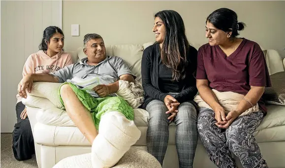  ?? BRADEN FASTIER/STUFF ?? Feroze Mohammed Ditta 51, is glad to be home with family, from left, daughters Sana, 21, and Ditta, 25, and wife Gulshad Ditta, after being released from hospital after being hit by two bullets in his leg and foot during the shooting at the Al-Noor mosque on Deans Ave.