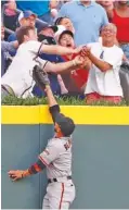  ?? THE ASSOCIATED PRESS ?? Fans battle for a ball hit for a two-run home run by the Atlanta Braves’ Freddie Freeman as San Francisco Giants left fielder Gregor Blanco looks on in the first inning Friday in Atlanta.