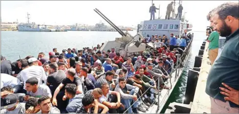  ?? MAHMUD TURKIA/AFP ?? Illegal immigrants, who were rescued by the Libyan coastguard in the Mediterran­ean off the Libyan coast, arrive at a naval base in the capital Tripoli on May 10.