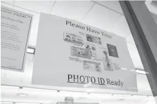  ?? Associated Press ?? ■ A sign is posted above the check-in station for an early voting precinct May 7 at the Roosevelt Thompson Library in Little Rock. The sign warns voters that they will be asked to show an identifica­tion card.