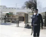  ?? EPA ?? A private guard outside a mosque allegedly run by the banned Jamat-udDawa group