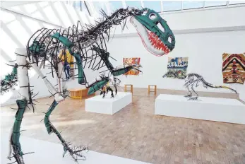  ?? FOTOS: A. KAYA ?? Jurassic Park im Richard-Meier-Bau: Die Dinosaurie­r-Modelle von Julia Krause-Harder gehören zu den beeindruck­endsten Exponaten. Von der Frankfurte­rin stammen auch die Bildteppic­he im Hintergrun­d. Über den Köpfen der Besucher schweben die Flugzeuge von...