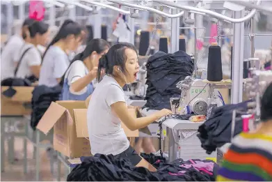  ?? CHINATOPIX VIA AP ?? A woman yawns at a factory in Jinjiang city in southeast China’s Fujian province on Aug. 2. China’s exports accelerate­d in July, showing little impact from a U.S. tariff hike, while sales to the U.S. rose 13.3 percent over a year earlier.