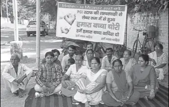  ?? MANOJ DHAKA/HT ?? Family of the missing newborn sitting on a dharna outside the Post Graduate Institute of Medical Sciences in Rohtak on Wednesday; (left) hospital staff holding a demonstrat­ion.