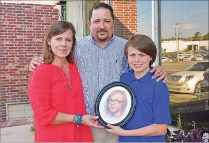  ?? STACI VANDAGRIFF/THREE RIVERS EDITION ?? Jennifer and Jeremy James and their son, Jonas, 12, hold a photo of Jesse Dylan James. The couple’s 14-year-old son died by suicide in September 2017, and the couple formed the Jesse Dylan James Foundation. The second Jammin’ for Jesse event is scheduled for 4:30-10 p.m. Saturday at the White County Fairground­s in Searcy. Bands will perform, and there will be food and activities, including a dunking booth, bounce houses and face-painting. The event is free, but donations will be accepted.