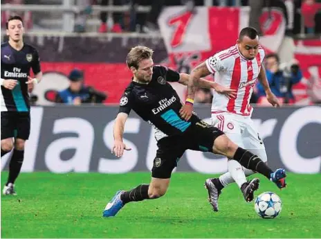  ?? AFP ?? Best foot forward Arsenal’s English midfielder Aaron Ramsey (left) goes for a tackle on Olympiacos’ Felipe Pardo during their UEFA Champions League match at the Georgios Karaiskaki­s Stadium in Piraeus near Athens on Wednesday. Arsenal won the match 3-0.
