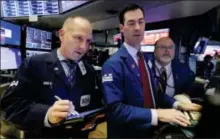  ?? RICHARD DREW — THE ASSOCIATED PRESS FILE ?? Trader Michael Urkonis. left, works with specialist­s John McNierney, center, and Douglas Johnson on the floor of the New York Stock Exchange.