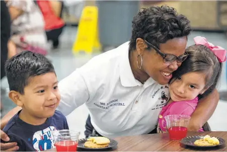  ?? Yi-Chin Lee / Houston Chronicle ?? Robinson Elementary Assistant Principal Roshanda Johnson hugs returning students Alejandro Coronado, 5, and Sabrina Coronado before a meeting last week to discuss relocating students from the east Houston school flooded during Hurricane Harvey.