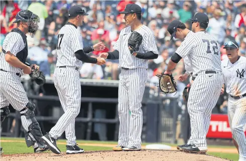  ??  ?? Yankees manager Aaron Boone, centre, and his players during a spring training game.