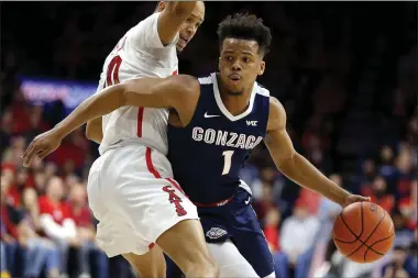  ??  ?? Rick Scuteri Gonzaga guard Admon Gilder (1) drives around Arizona guard Jemarl Baker Jr. in the first half of an NCAA college basketball game, Saturday, Dec. 14, 2019, in Tucson, Ariz.