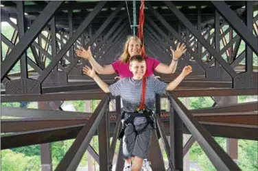  ?? COURTESY OF ADVENTURES ON THE GORGE ?? Nick and Melissa Kossler pause for a photo as they walk across West Virginia’s New River Bridge.